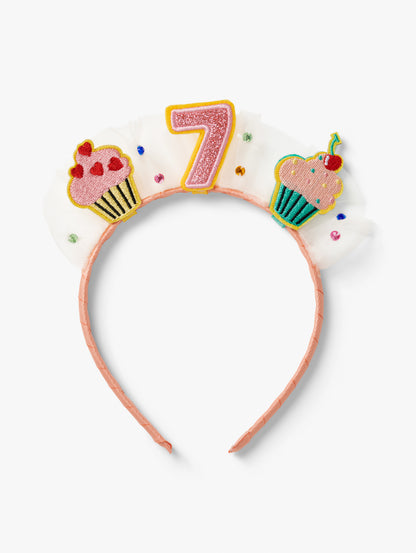 Stych Birthday Number Crown with central number 7, cupcake patches and tulle gem detail on a pink headband.